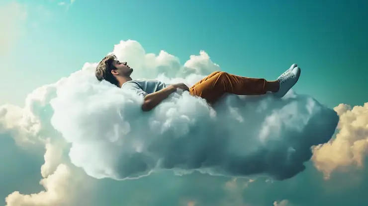 Homme allongé sur un nuage, détendu, dans un ciel bleu
